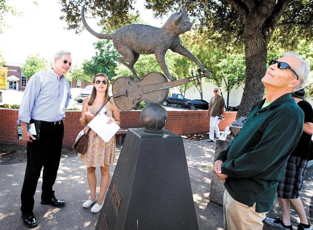 Craig Watson, left, director of the California Arts Council, admires Sandra Kay Johnson’s “Hey Diddle Diddle” sculpture during a 2012 walking tour of public art and cultural venues in downtown San Luis Obispo led by ARTS Obispo program director Jenna Hartzell, center. Also on the tour was City Councilman John Ashbaugh, right.