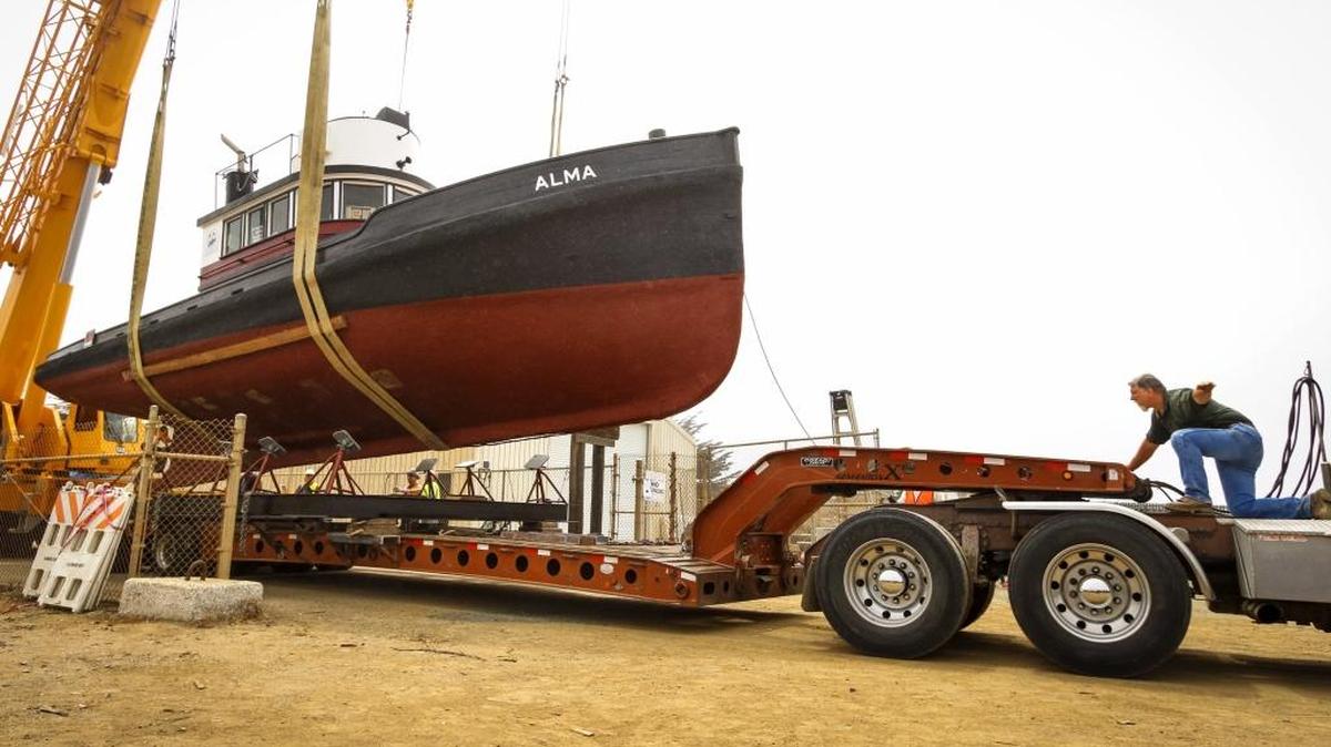 A worker directs the crane operator as the 48-foot tugboat Alma is moved onto a truck Thursday to be transported from the Morro Bay Harbor Department Boathouse to its new home at the future Morro Bay Maritime Museum on the Embarcadero.