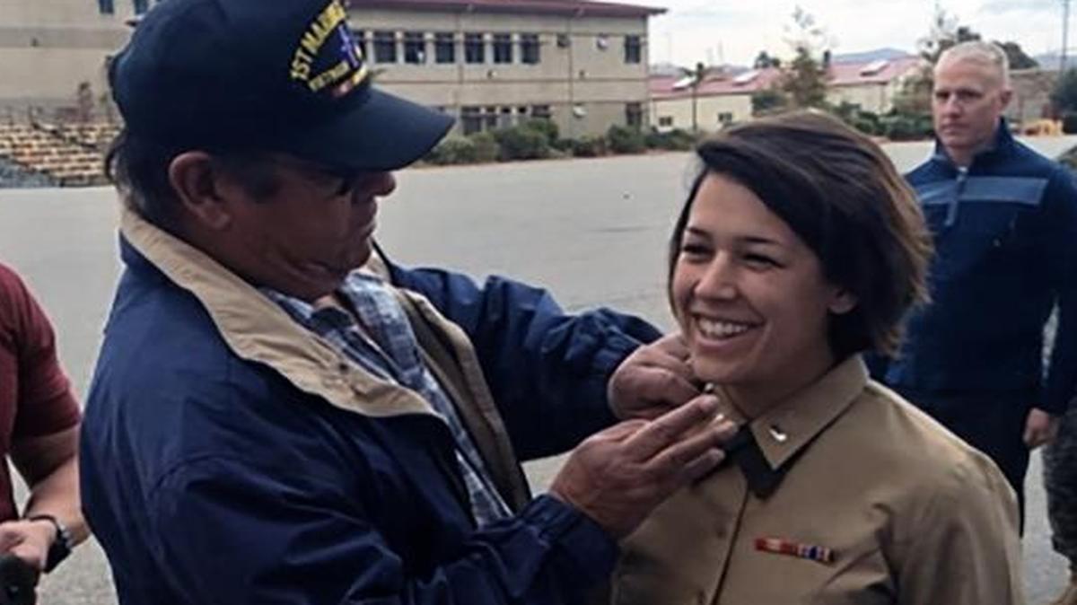 Louis Mello II pins his daughter Maggie’s Marine First Lieutenant’s bars on her.