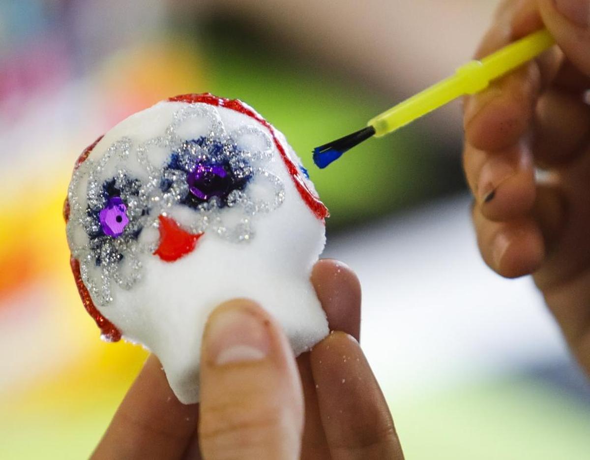 Madison Schwarz colors her skull during a sugar skull decorating workshop at Cuesta College in San Luis Obispo in 2016.