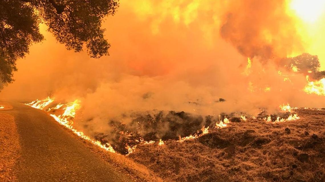 Flames from the Whittier Fire near Lake Cachuma burn through a ranch on the south side of Highway 154.