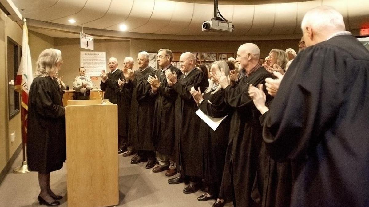 Former San Luis Obispo Court Commissioner, Gayle Peron, was sworn in as a San Luis Obispo County judge on Friday. Peron, left, smiles as other judges applaud during the ceremony.