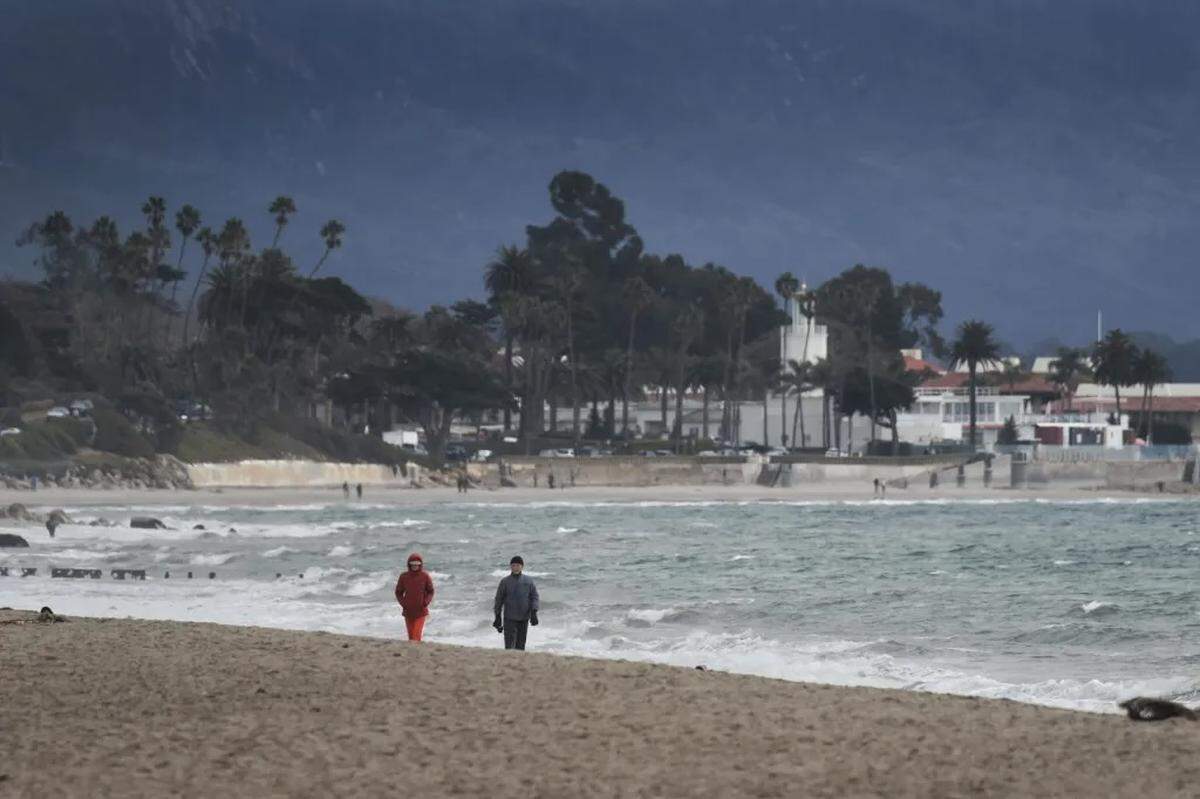 Two people are bundled up against the cold Sunday morning on East Beach in Santa Barbara on Jan. 26, 2025.
