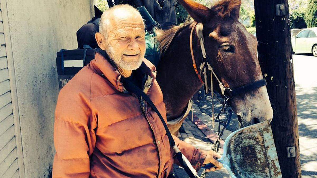 A 2014 Tribune file photo shows “Mule Man” John Sears and one of his mules during a visit to San Luis Obispo.