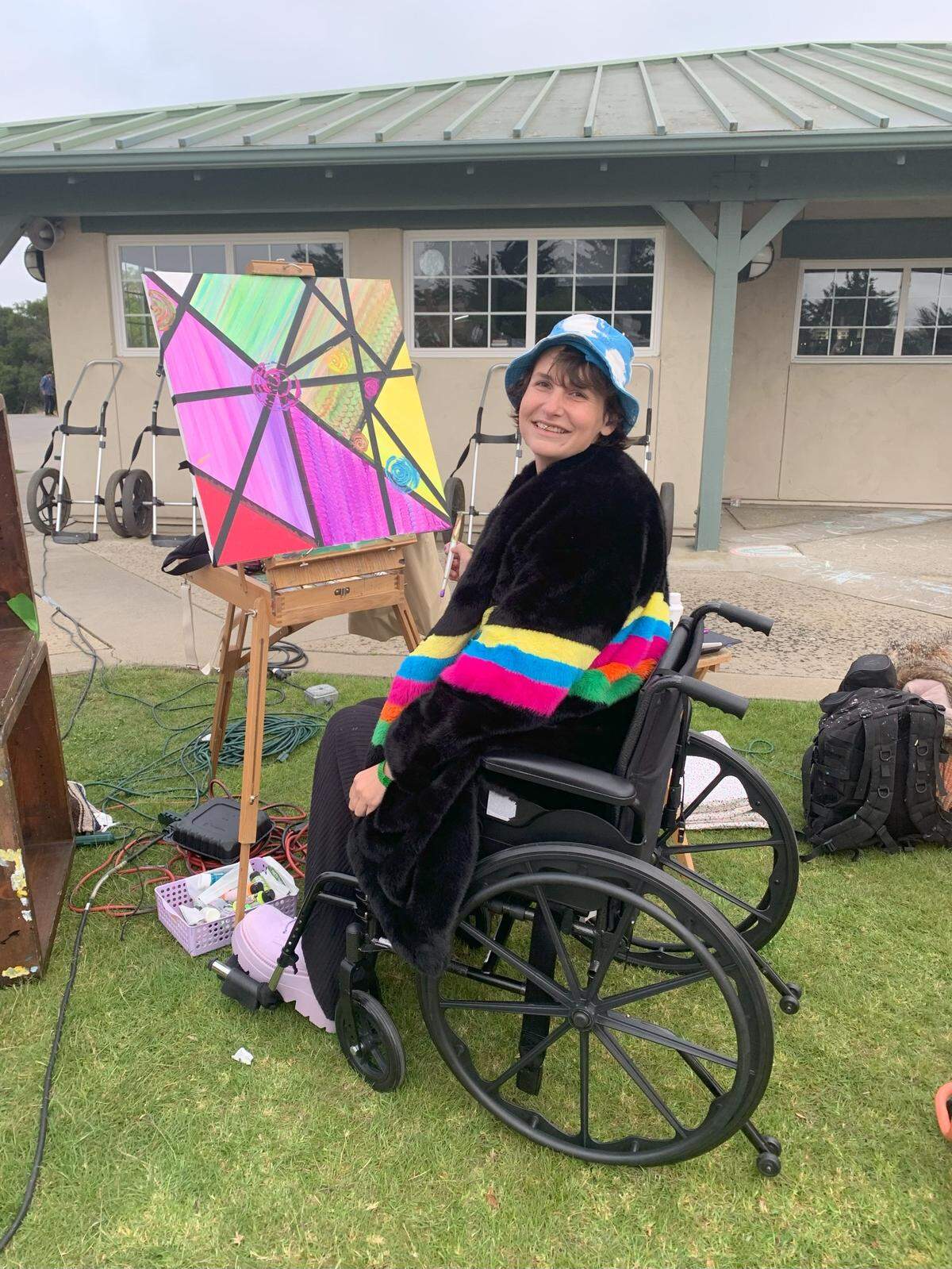 Faith LeGrande painting in their wheelchair at an event hosted by Subsessions at The Siren El Chorro.