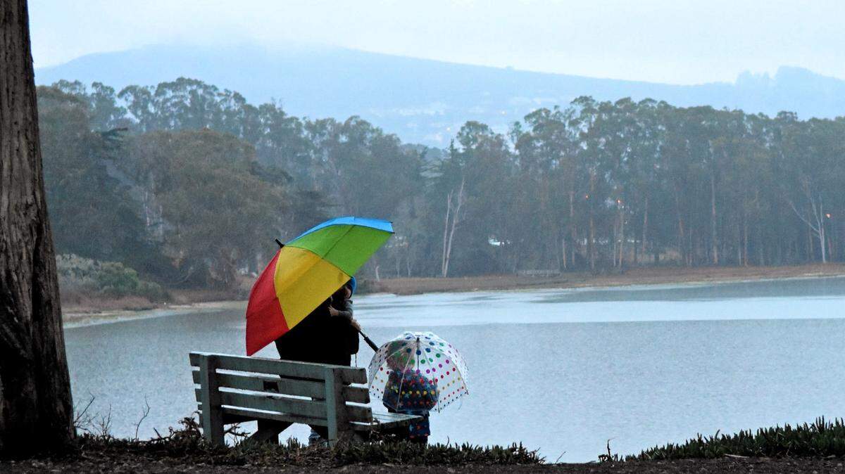 A family admires the King Tide at Baywood Pier.