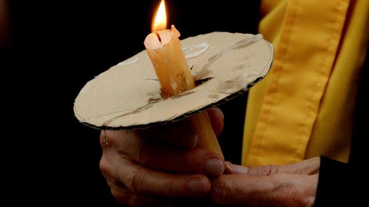 A person holds a lit candle during a vigil for those recently wounded and killed during a white nationalist rally in Charlottesville, Virginia, at the Caddo Parish Court House in Shreveport, Louisiana, on Sunday, August 13, 2017.