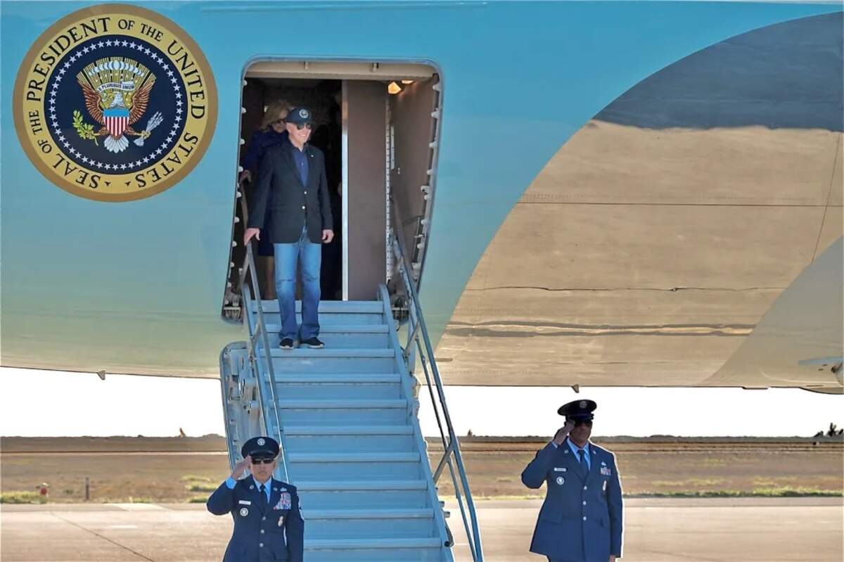 Military members salute as former President Joe Biden prepares to deplane Monday, Jan. 20, 2025, at Vandenberg Space Force Base.