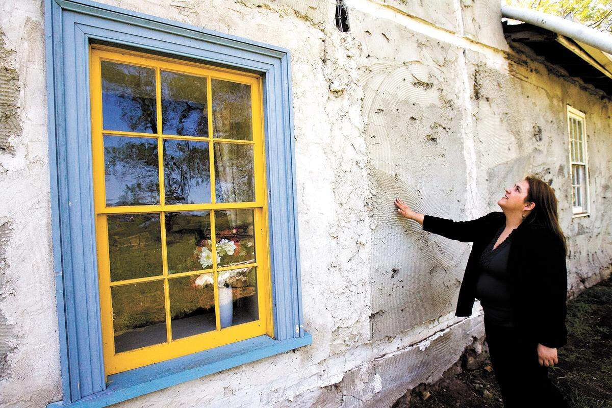 Marina Washburn inspects the exterior of the Dana Adobe in 2010..