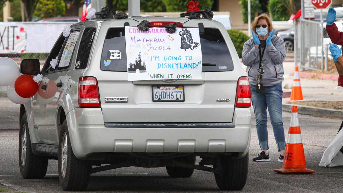 Katherine Gildea cruises through Paso Robles High School’s drive-through senior celebration with a sign that says she’s “Going to Disneyland! When it reopens.” The school held a parade for 2020 graduates as they came to pick up their yearbooks and caps and gowns. A formal graduation is planned for July due to coronavirus restrictions prohibiting mass gatherings.
