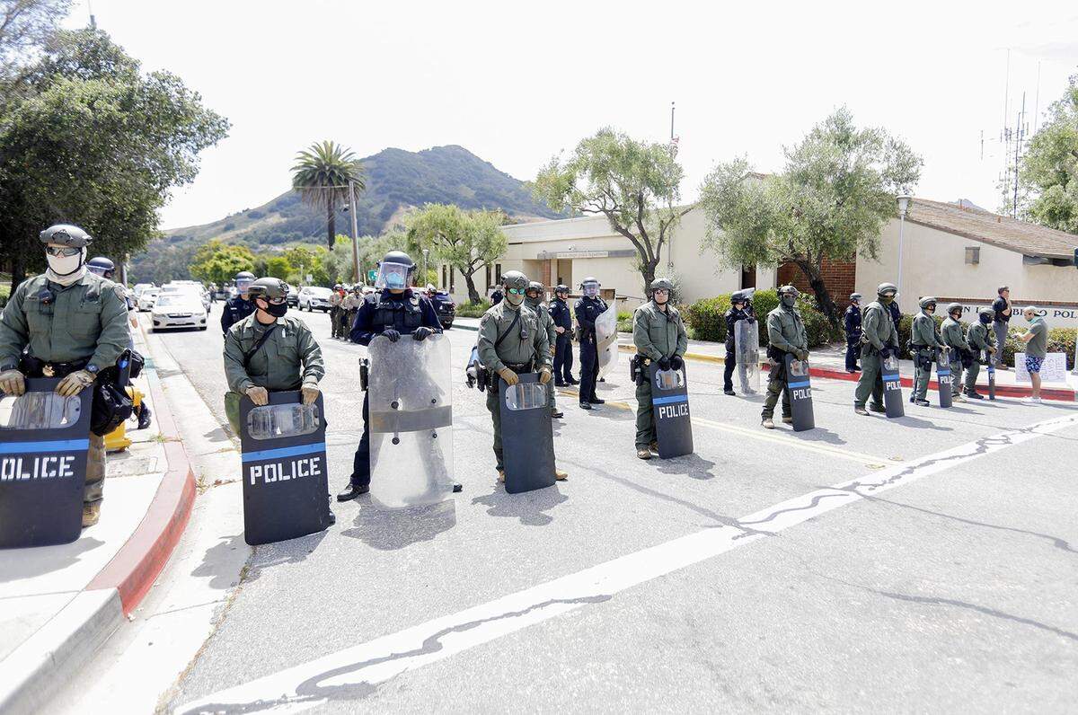 San Luis Obispo police officers and SLO County Sheriff deputies form a line of protection in front the San Luis Obispo police station on Walnut Street, June 1, 2020.