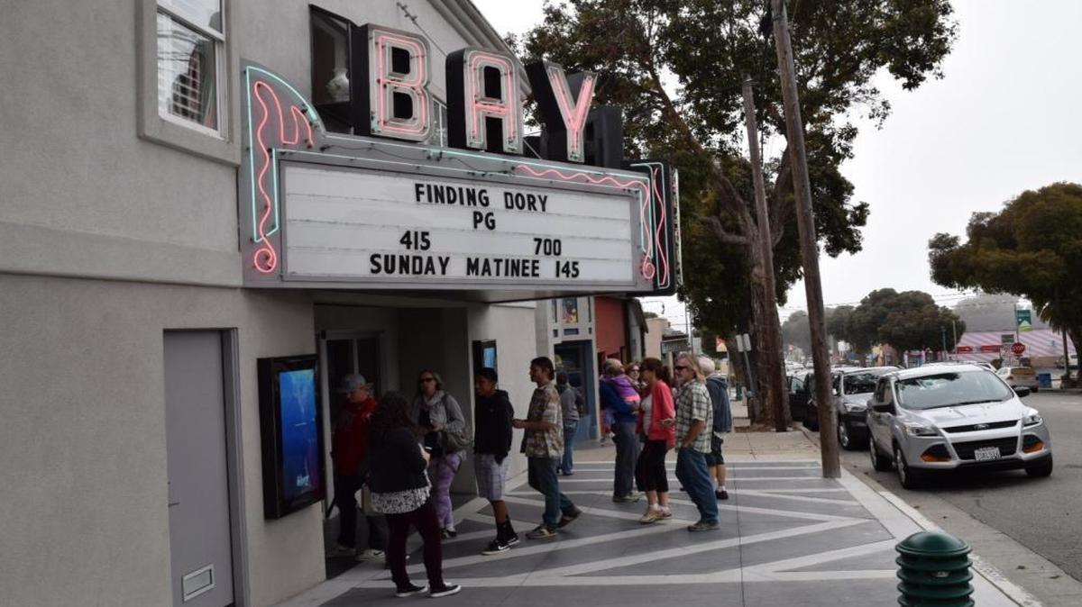 Moviegoers head into the Bay Theatre in Morro Bay for the first showing of “Finding Dory." The theater is up for sale.