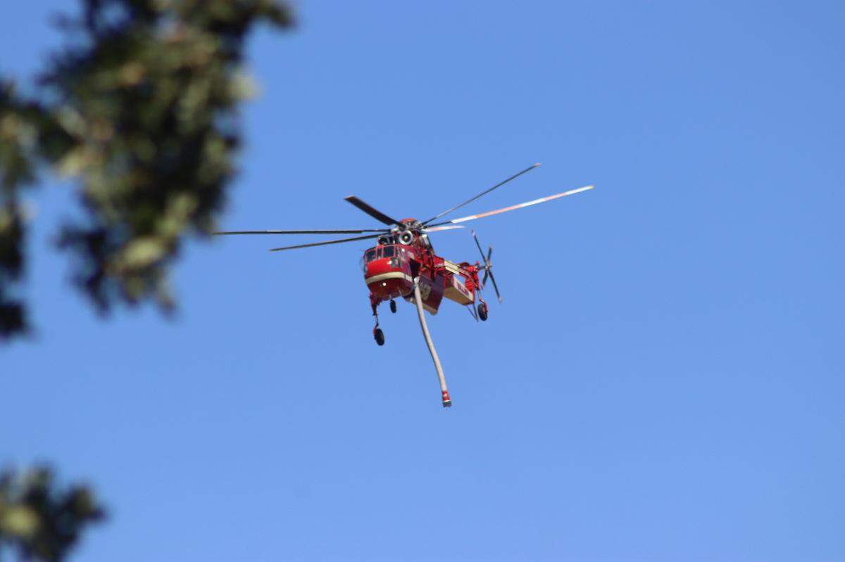 A helicopter flies over the Llano Fire in Atascadero on June 28, 2025.