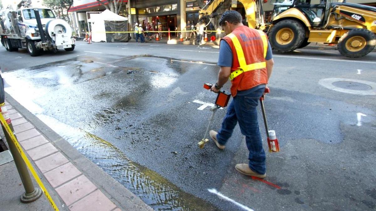 A Southern California Gas Co. worker checks out the location of a water leak Thursday evening on Higuera Street in San Luis Obispo. The leak disrupted a portion of Farmers Market.