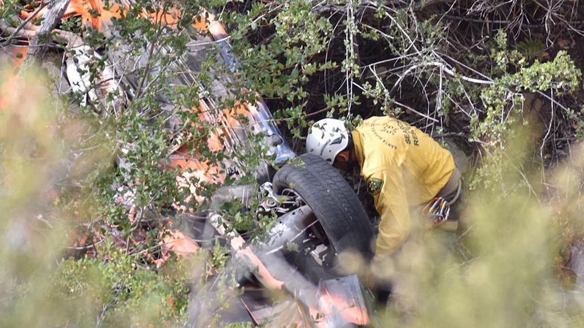 A Santa Barbara County Search & Rescue Team member examines the wreckage of a vehicle that was discovered Friday, November 3, 2017, some 300 below Gibraltar Road near Santa Barbara. Human remains were found near the vehicle.