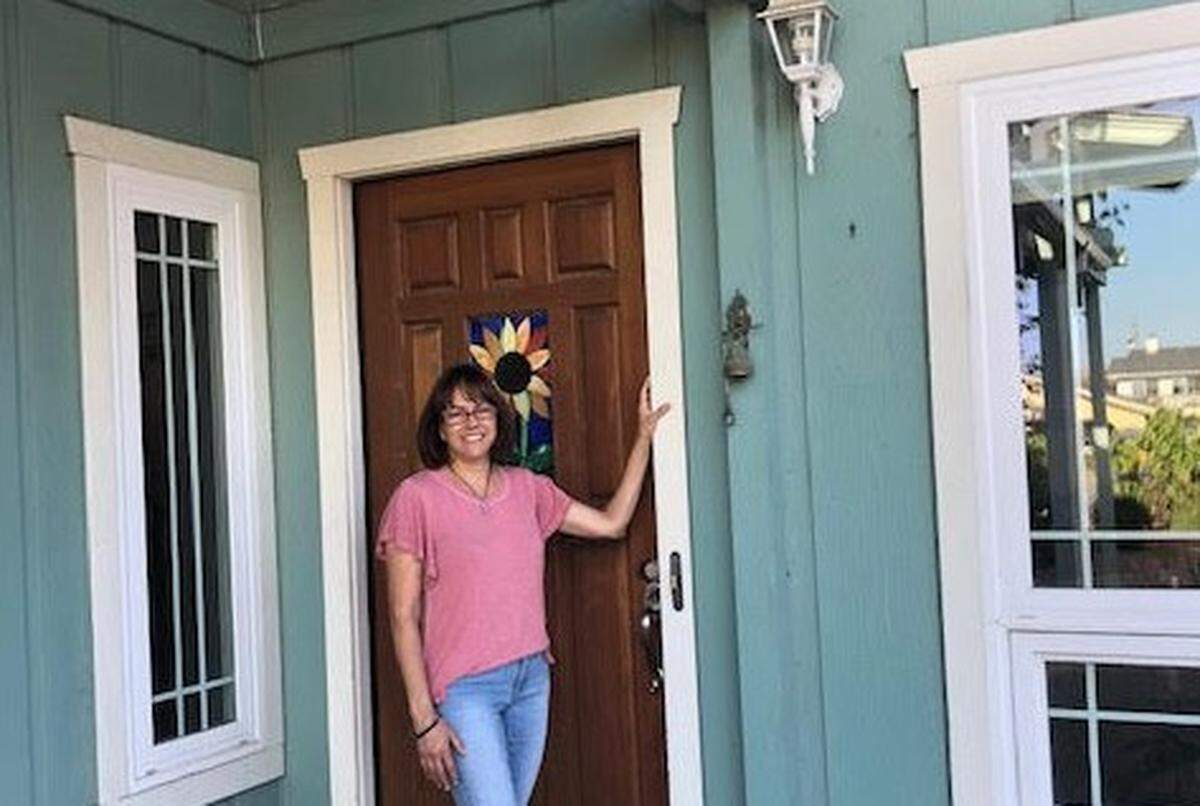 Wendy Greene stands in the doorway of her Los Osos home. Greene’s housing costs are more expensive than she anticipated due to Los Osos Wastewater Project supplemental property taxes.