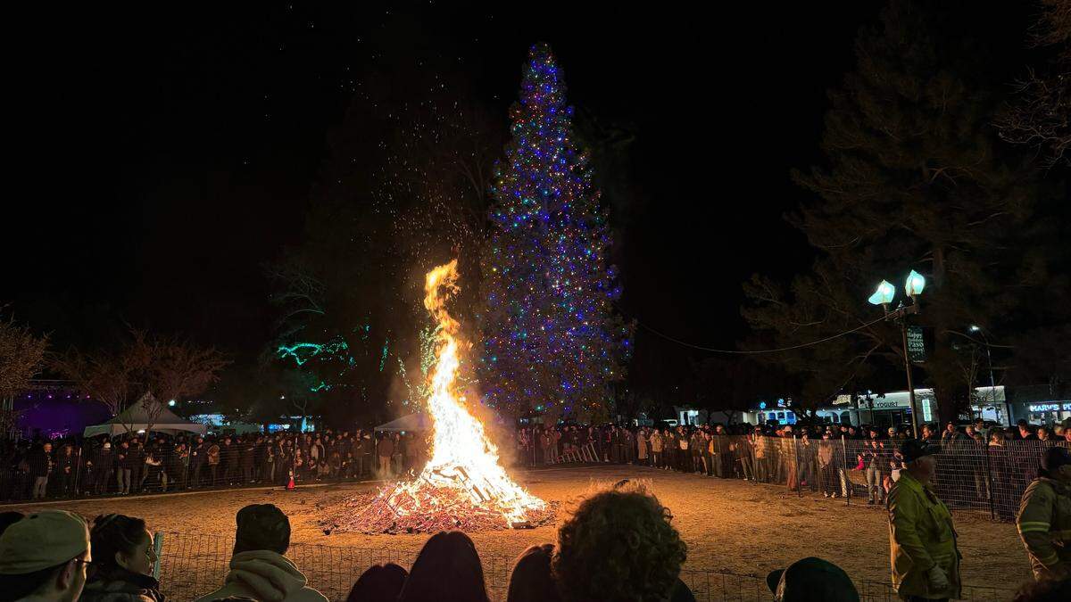 Revelers circle around the giant bonfire during Paso Robles’ New Year’s Eve celebration at the Downtown City Park on Dec. 31, 2023.