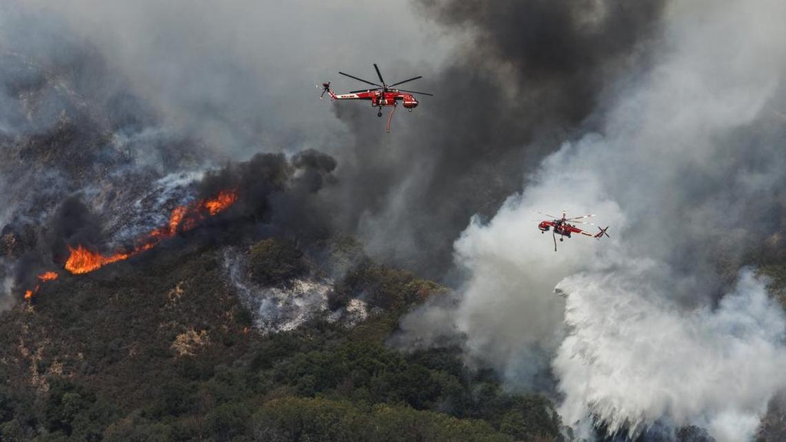 Fire attack helicopters drop water on the southwestern front of the Chimney Fire on Thursday.