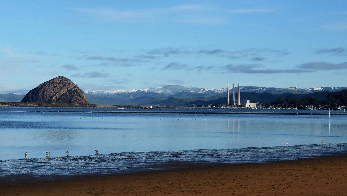 Snow dusts the hills behind Morro Bay and Cayucos in a view from Los Osos on Thursday morning, Feb. 23, 2023.