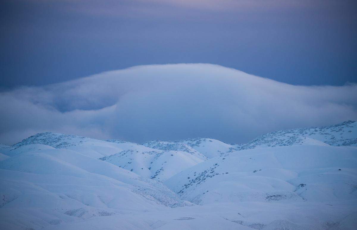Clouds layer of snowy mountains over a white valley in eastern San Luis Obispo County. Heavy overnight snow turned the California Valley and Temblor Range near the Carrizo Plain into a scene that looks more like the Arctic than San Luis Obispo County on Saturday, Feb. 25, 2023.