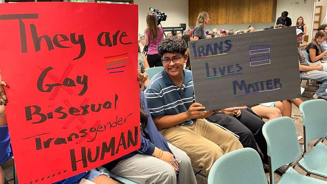 Members of the audience hold signs supporting LGBTQ+ students at the Paso Robles school board meeting on Tuesday, Aug. 23, 2022. The board approved a resolution protecting traditional, gender-specific titles.