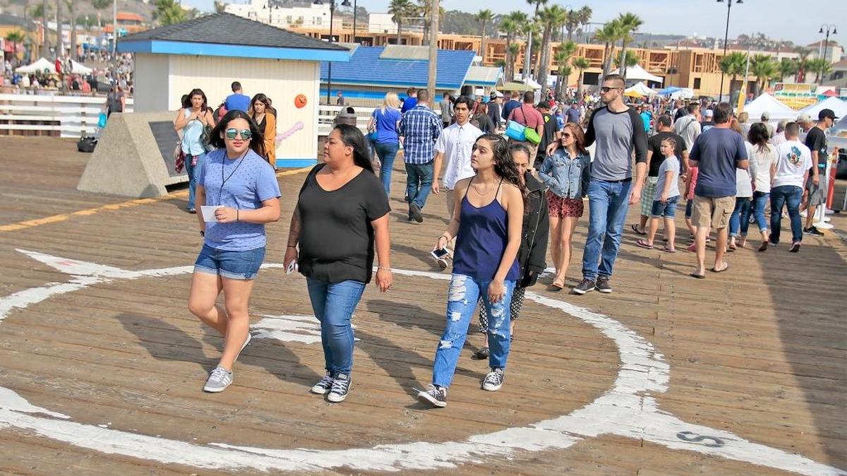 Festivalgoers walk on the Pismo Beach Pier.