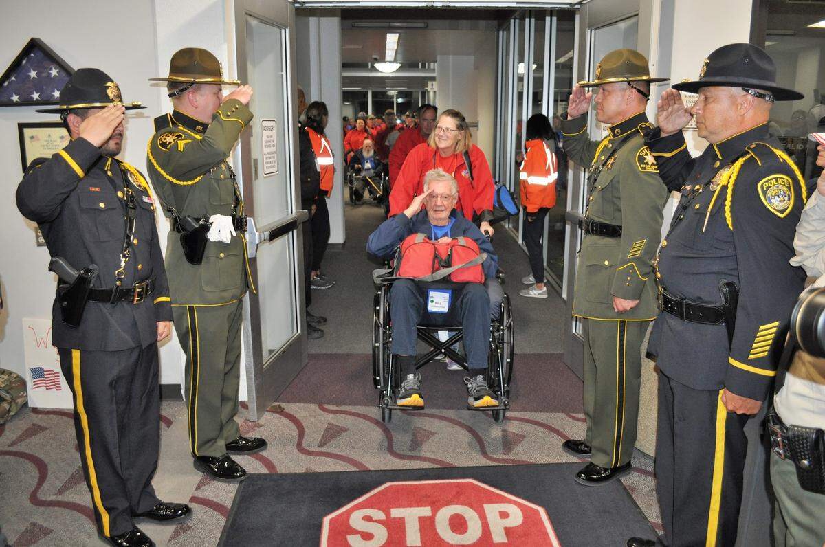 World War II veteran Bill Livingston, 96, and guardian Beth Newell, his niece, are saluted by law enforcement officers as hundreds of supporters, families and friends turned out at the Santa Maria Airport on Wednesday evening, April 26, 2023, to welcome veterans returning from an Honor Flight trip to Washington, D.C.