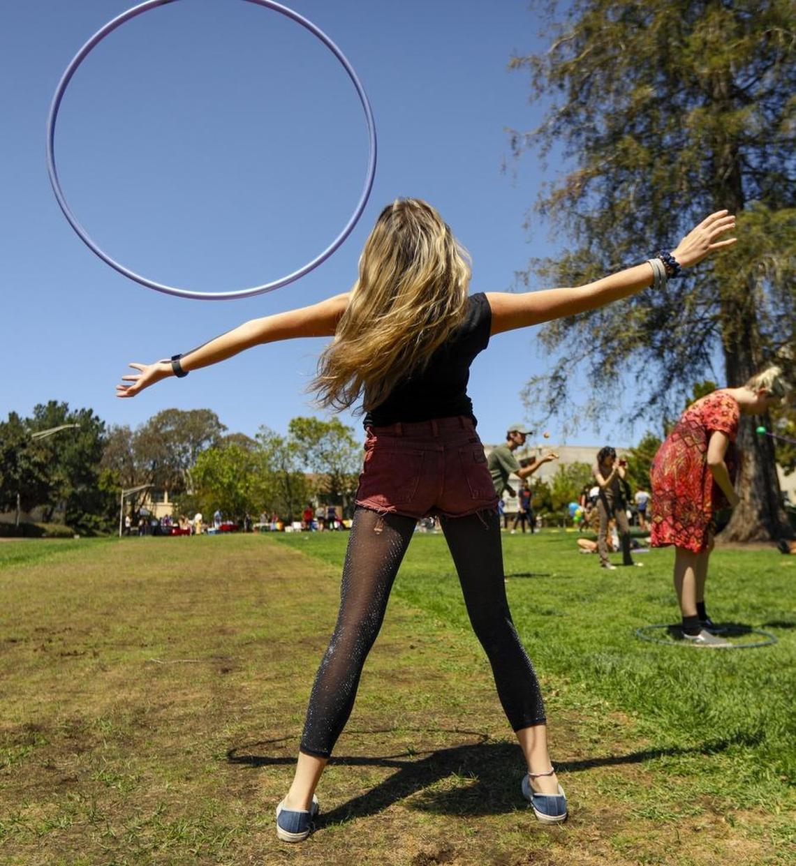 A member of Cal Poly’s Merry Hoopsters hula hooping club tosses a hoop at Dexter Lawn at Cal Poly.