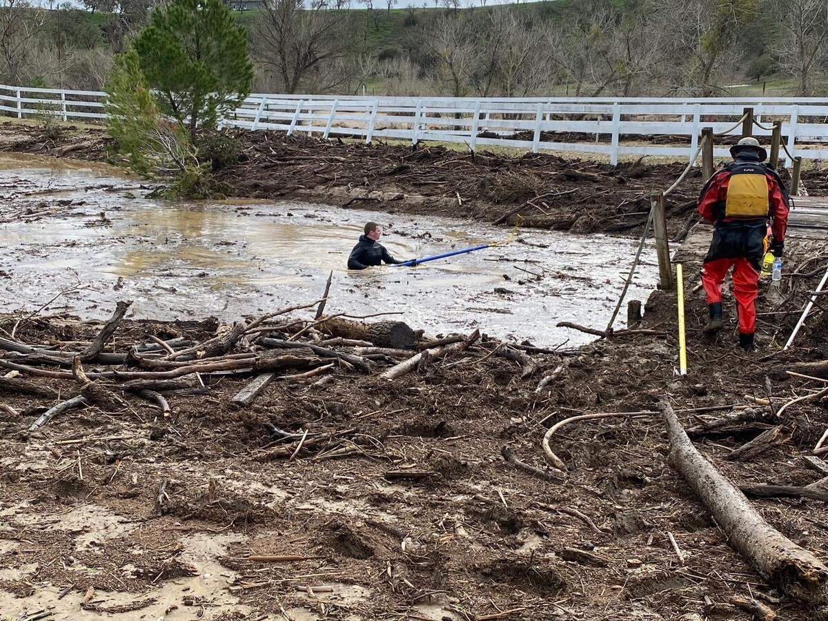 Searchers check through floodwaters and debris for any sign of 5-year-old Kyle Doan on Wednesday, Jan. 11, 2023, two days after he disappeared in swollen San Marcos Creek near San Miguel.