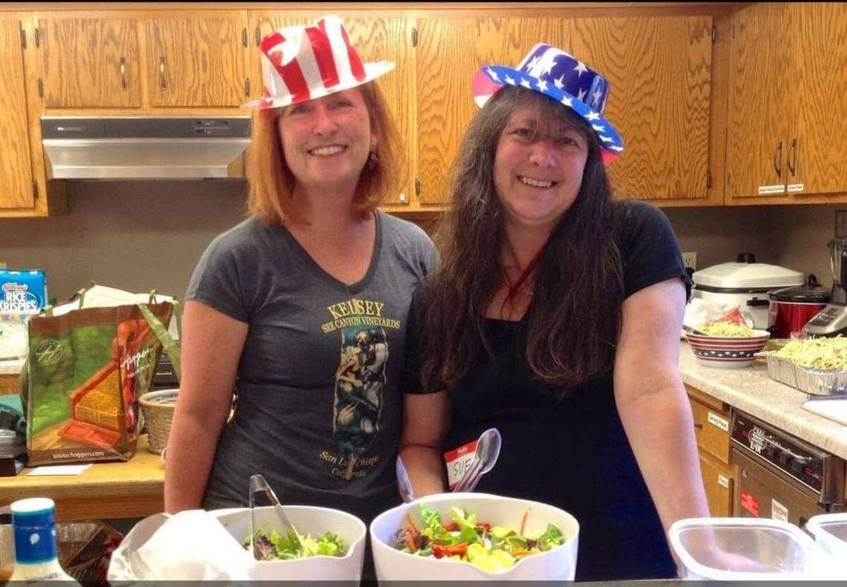 Lisa Lazzara and Susan Waag at a Fourth of July dinner for the homeless at United Church of Christ. Waag helped Lazzara though the cold-capping process that preserved her hair during chemotherapy for breast cancer.