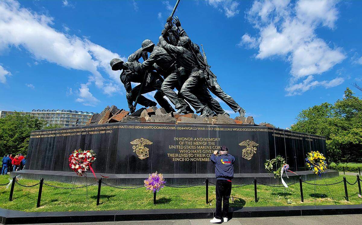 An Honor Flight participant from the Central Coast takes a photo of the Iwo Jima statue and the Marine Corps War Memorial in Washington, D.C., on Tuesday, April 25, 2023.