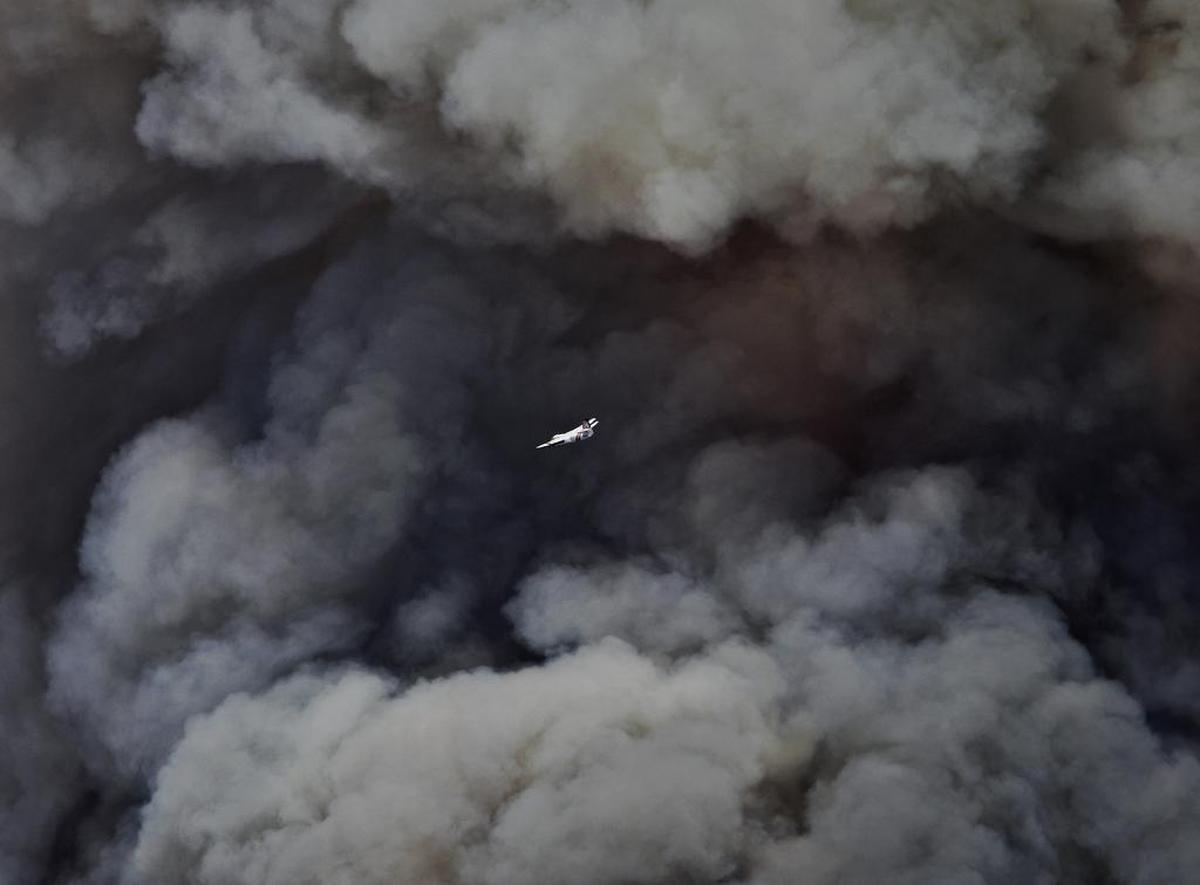 An air tanker flies in front of a plume of smoke rising from the southwest front of the Chimney Fire near Lake Nacimiento on Aug. 18, 2016.