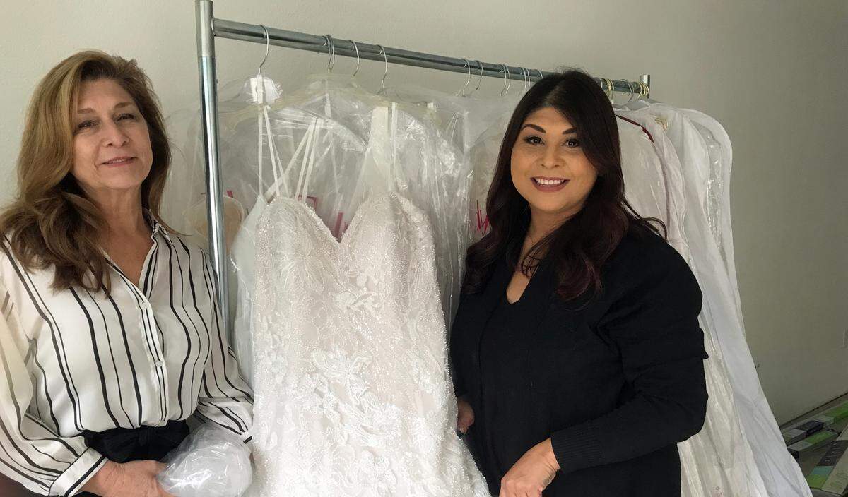 From left, mother and daughter Gail and Crystal Reynoso, owners of new Cambria wedding shop A Little Love Bridal by the Sea, check in a $2,700 bejeweled-lace gown by Italian designer Eddy K.