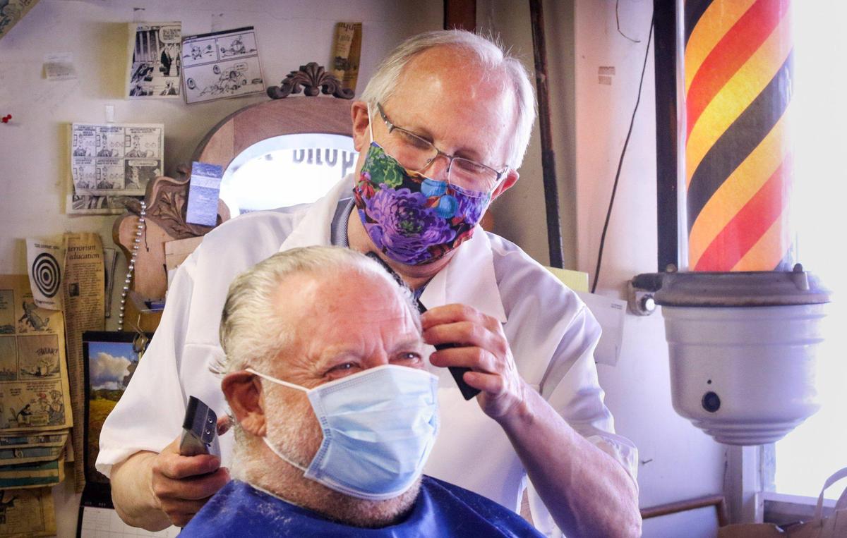 Ray Shearer has been cutting hair at the Anderson Barber Shop for 50 years but has had to take the last two months off. His client, Bob Nichols, had not had a haircut for the 2 months that coronavirus restrictions were in place.