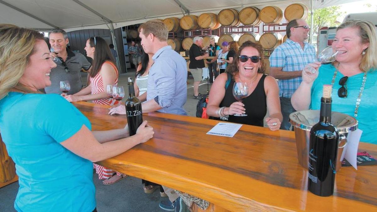 Vintage Paso: Zinfandel Weekend kicks off this Friday with a winemaker’s dinner. At J Dusi Winery in Templeton, Jaime Christensen serves Dusi Vineyard zinfandel to Katrina Dodson, left, and Carla Anderson, right, both of San Diego, during Vintage Paso: Zinfandel and Other Wild Vines in March 2015.