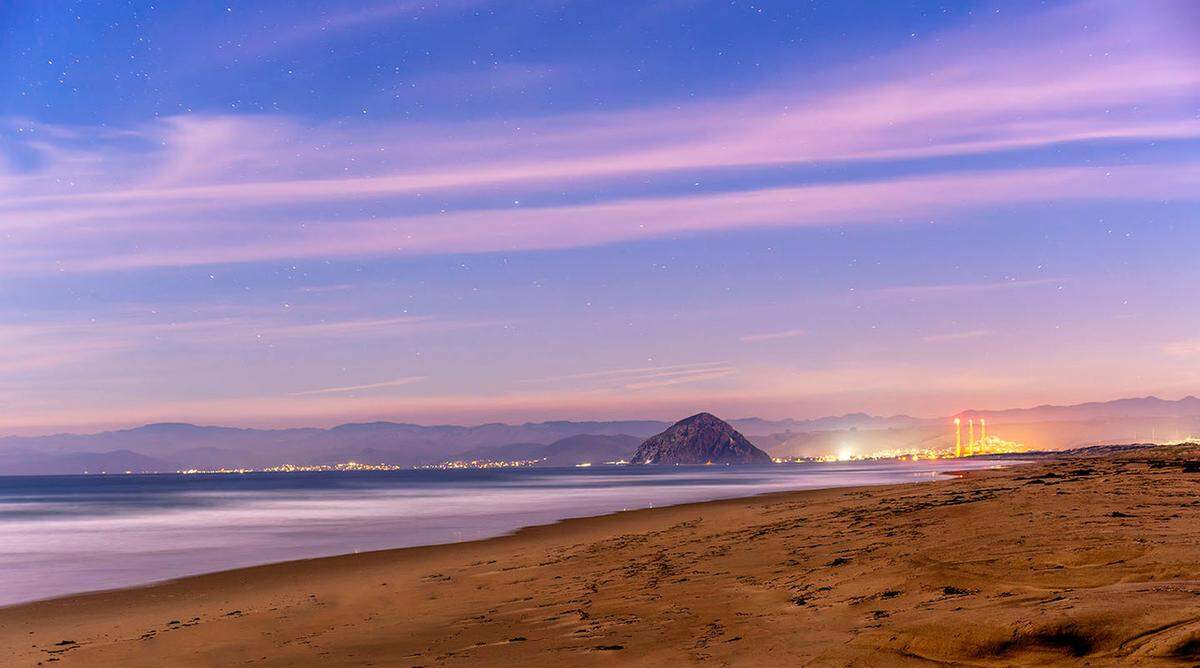Twinkly stars and wispy clouds fill the sky over Montana de Oro State Park and the Estero Bay in 2022. San Luis Obispo County saw $2.3 billion in total travel spending in 2023, according to a new report.