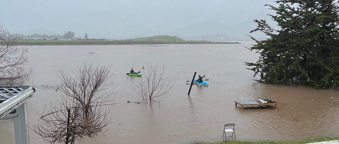College students paddle out of their back yard into Laguna Lake to help families retrieve their floating away furniture as a storm pounded San Luis Obispo on Jan. 9, 2023.
