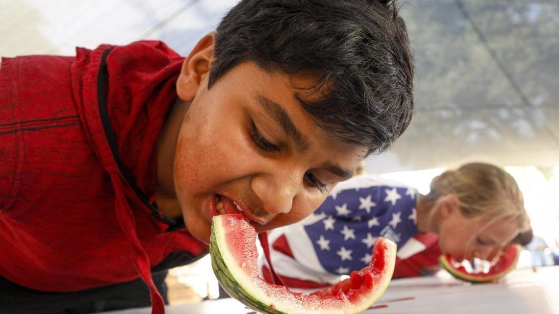Krish Patel, 13, mows down his watermelon on the way to a first-place finish in the junior division of the watermelon-eating contest Wednesday at the California Mid-State Fair.