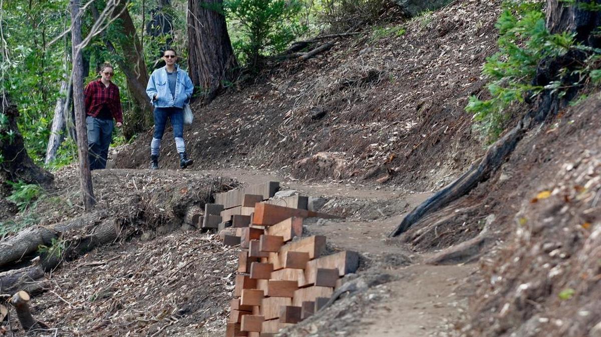 In this photo taken March 30, 2017, two women walk north on the new Pfeiffer Canyon foot trail that is open to residents traveling around the former Pfeiffer Canyon bridge in Big Sur. The trail will soon open to the public.