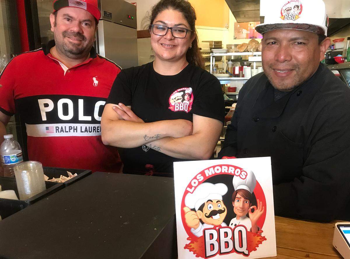 Los Morros BBQ owner-partners Miguel Fuentes, left, and Arturo Guatemala, right, flank employee Paulina Salcedo as they prepare for a long-awaited grand opening of the new eatery Monday, Aug. 14, 2023.