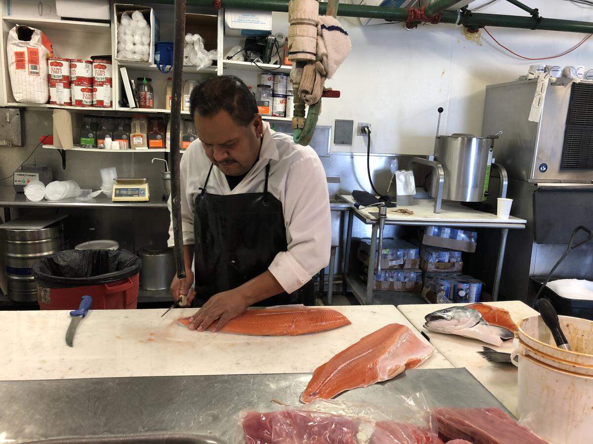 Jose Salazer fillets a fresh salmon at Giovanni’s Fish Market in Morro Bay. The fish produced seven pounds of meat for sale.