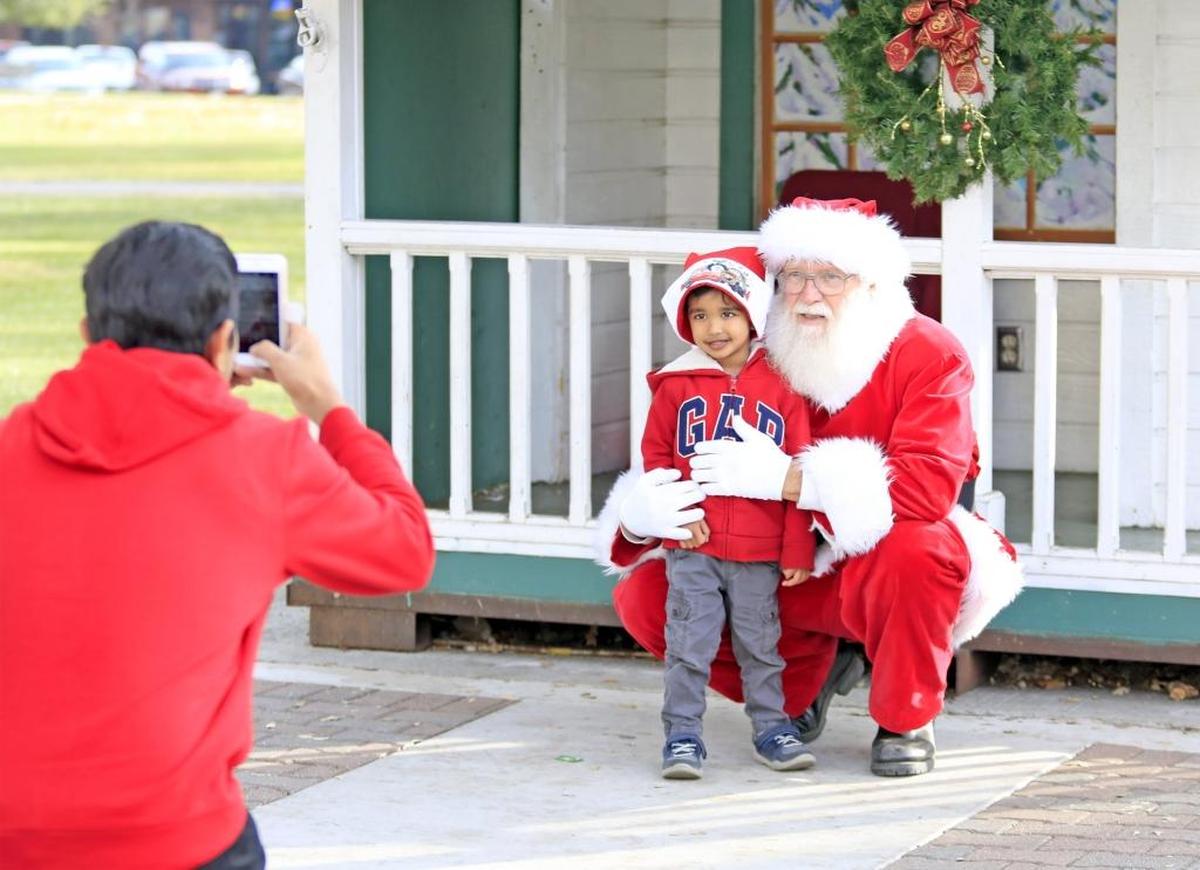 Siddarth Goel, 4, of Sunnyvale, gets a cute shot by his father, Vaibhav Goel, with Santa Claus in Downtown City Park in Paso Robles in 2017.