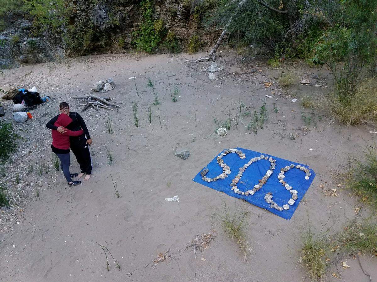 Krystal Ramirez and Hunter Whitson comfort each other while waiting for help, stranded at Arroyo Seco River.