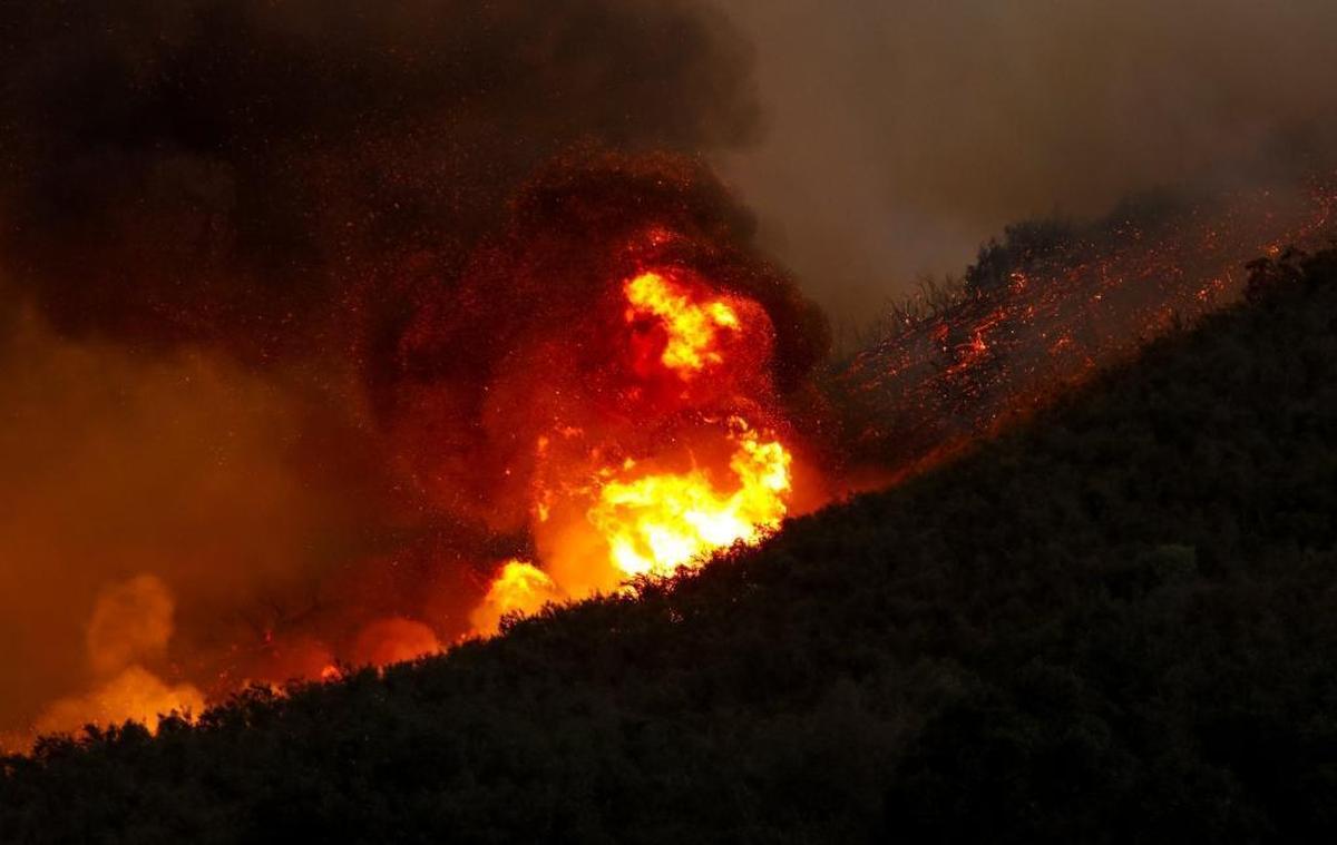 Flames from the Hill Fire burn along a ridge near Huer Huero Road.
