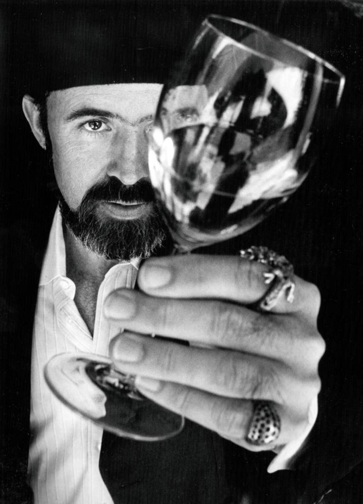 Archie McLaren, organizer for KCBX Wine Auction Classic, checks a wine for color in 1986.