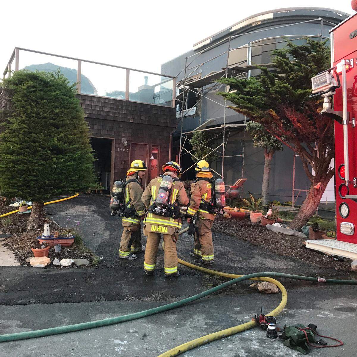 Firefighters begin cleaning up after a fire raced through the upper level of a Sherwood Drive hom in Cambria on Thursday, Oct. 20, 2022.