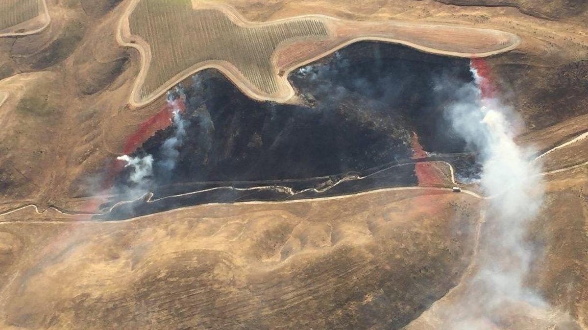 Cal Fire crews work to contain a blaze that burned 15 acres of grassland