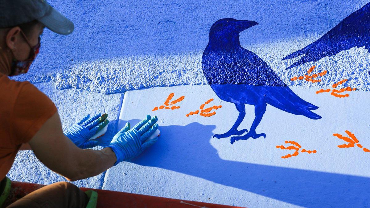 Sally Lamas is one of the artists participating in the city’s Public Art pavement projects. Here she adds crow foot prints to murals at the corner of Pacific and Nipomo Streets.