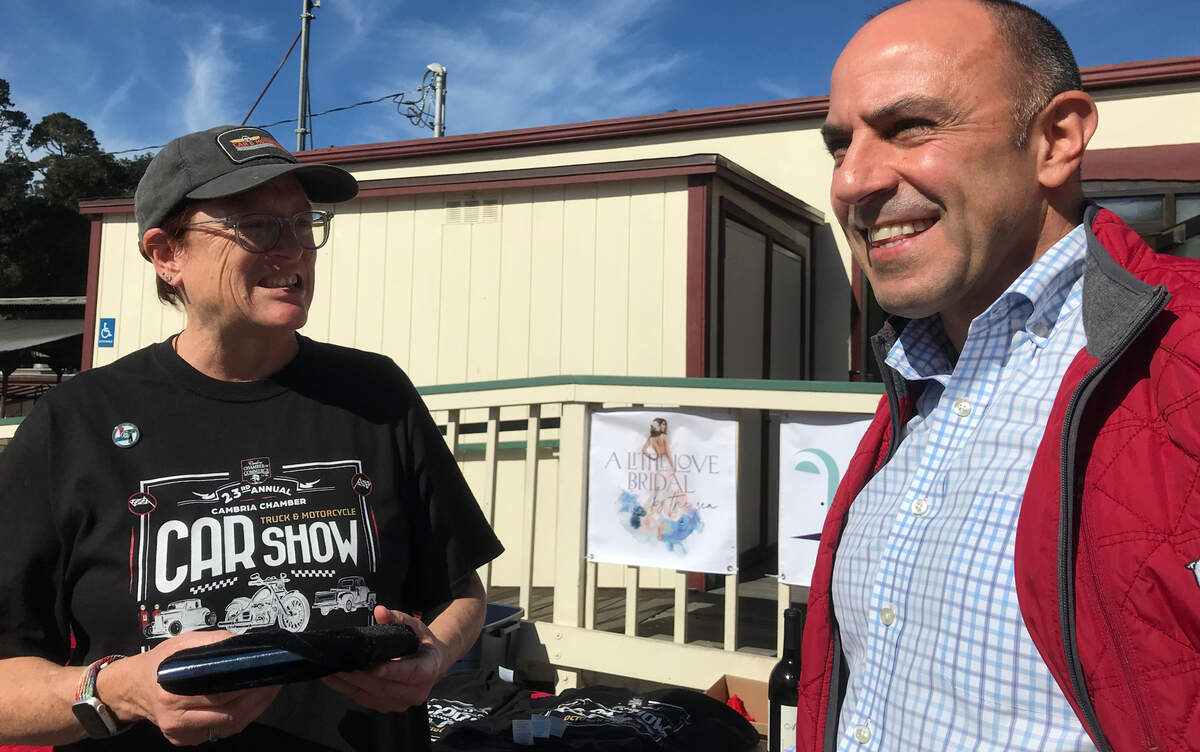 U.S. Rep. Jimmy Panetta, left, is greeted at the Cambria Chamber of Commerce’s 23rd annual car show on Saturday, Oct. 21, 2023, by the chamber’s Executive Director Lorienne Schwenk. The congressman, who had flown back to California from Washington D.C. earlier that morning, spoke briefly to attendees before heading to another function in Paso Robles.