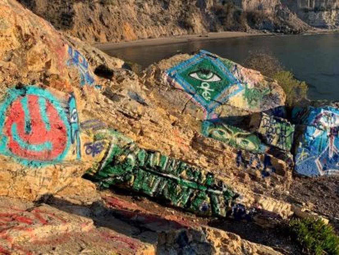 Graffiti artists have painted rocks along the cliffside at Cave Landing. The county recently approved a plan to remove graffiti and clean up the area.
